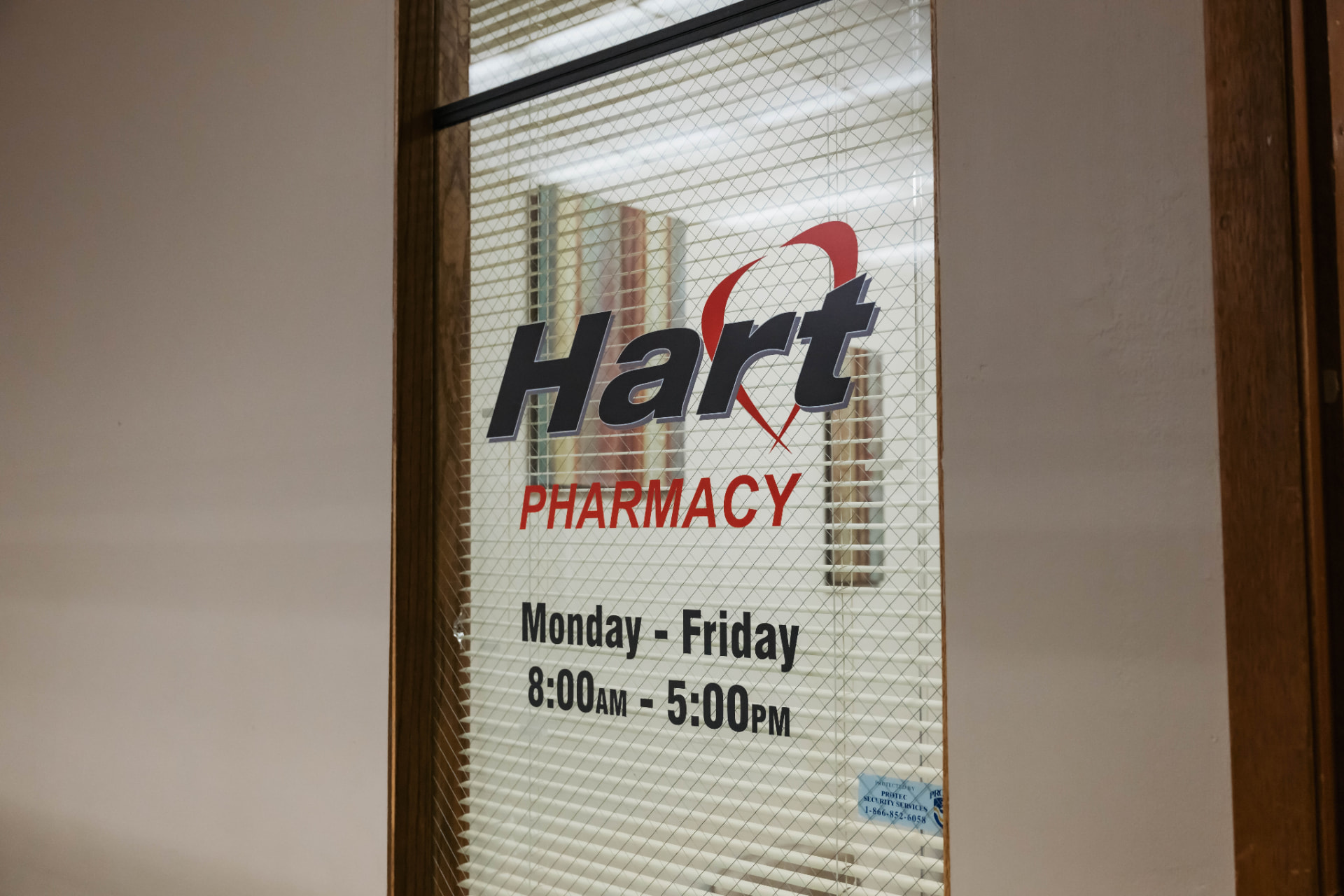Hart Pharmacy at Comcare entrance sign with Monday through Friday 8:00 AM to 5:00 PM hours